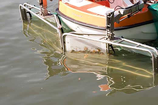 Cestas de recogida de la embarcación tipo pelican barriendo la superficie del agua en Bilbao