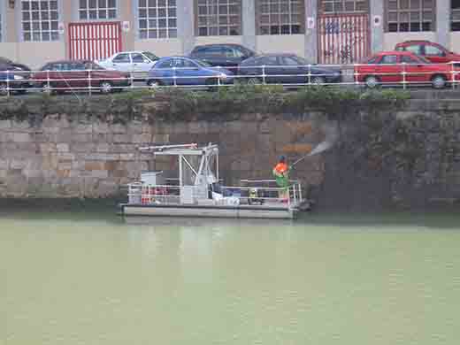 Operador de Urgarbi realizando la limpieza con agua a presión del muelle en Bilbao
